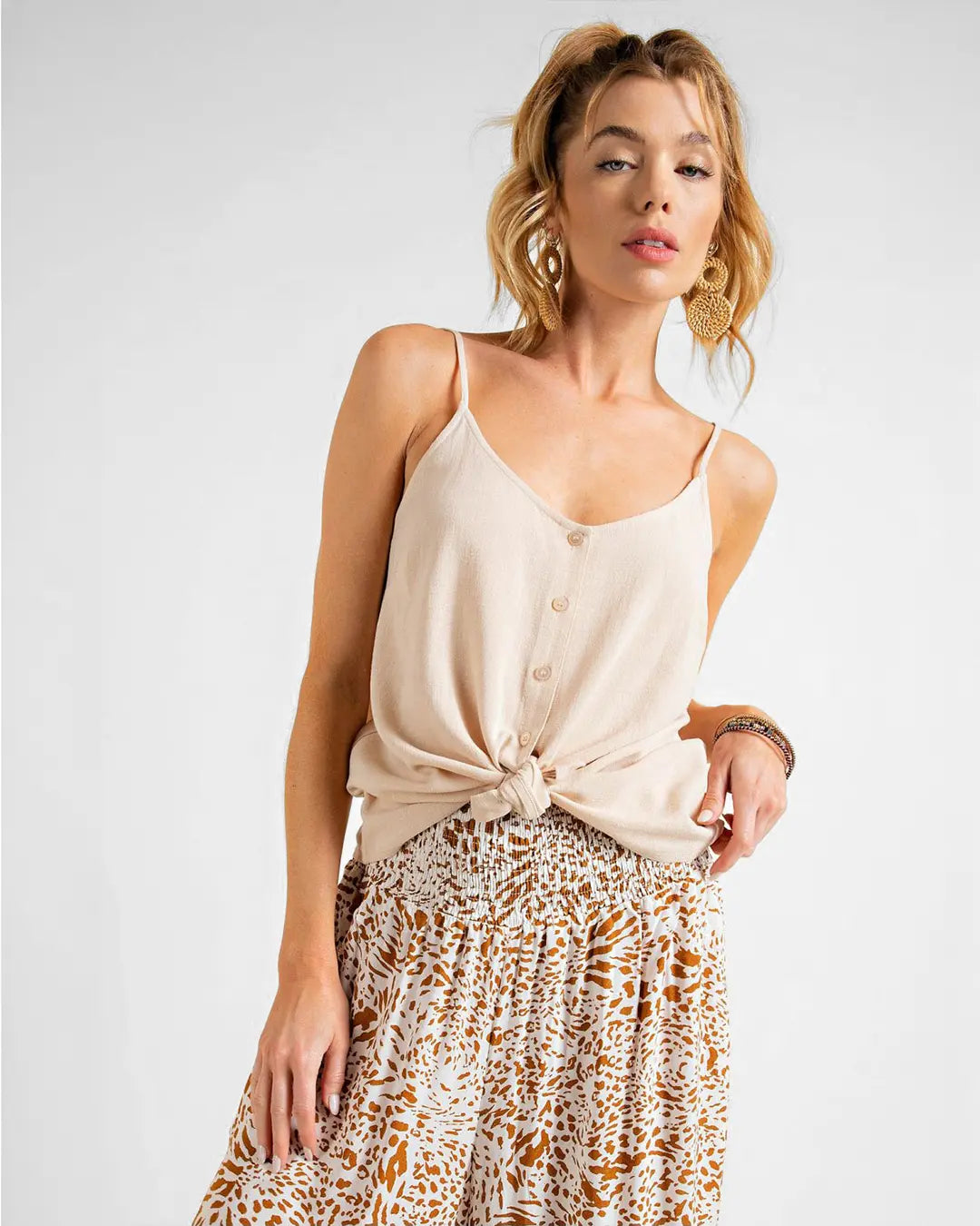 The perfect top to throw on and go! Super lightweight in the prettiest light hues, this tank top features functional buttons down the front with a scooped neckline and spaghetti straps.