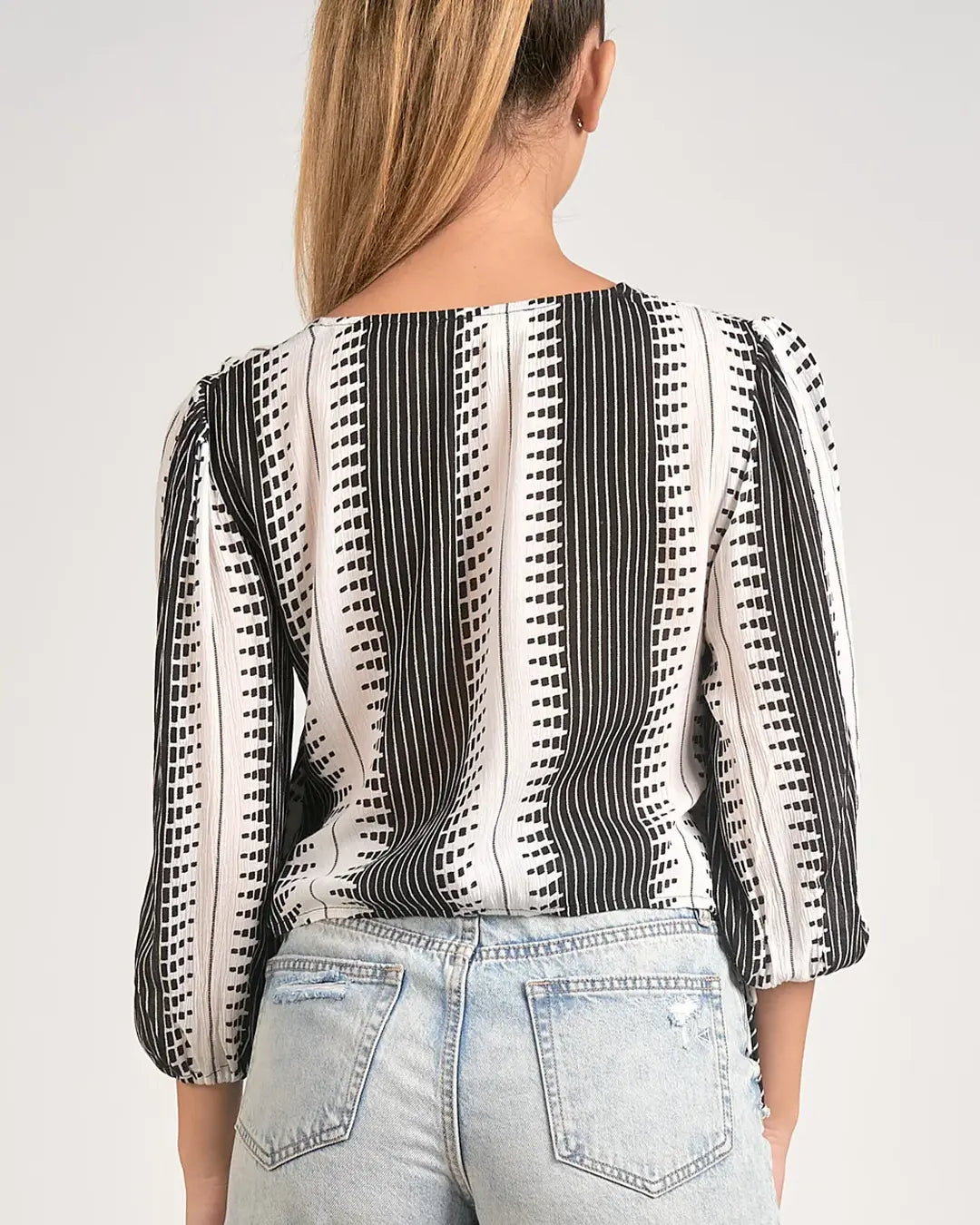 Elevate your wardrobe with our stylish Long Sleeve Black and White Twist Front Kenya Top, featuring a flattering V-neck and twist front detail. Perfect for adding a touch of sophistication to any outfit, this top is a versatile must-have for every fashionista.