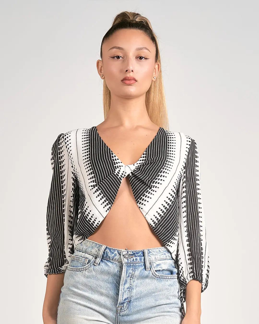 Elevate your wardrobe with our stylish Long Sleeve Black and White Twist Front Kenya Top, featuring a flattering V-neck and twist front detail. Perfect for adding a touch of sophistication to any outfit, this top is a versatile must-have for every fashionista.